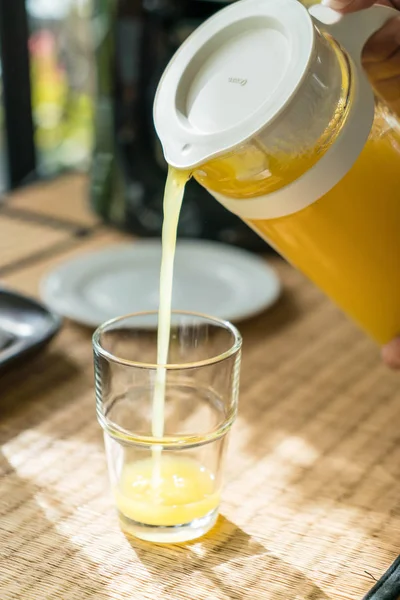 pouring orange juice in a glass