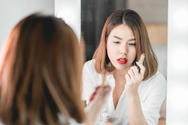 Genç güzel Asyalı ayna yakınındaki makyaj yapma kadın