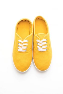 beyaz zemin üzerine sarı spor ayakkabı