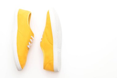 beyaz zemin üzerine sarı spor ayakkabı