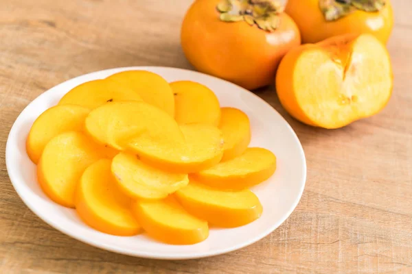 Sliced persimmon on plate — Stock Photo, Image