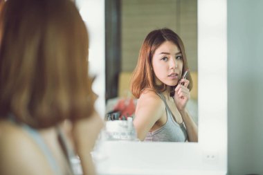 Genç güzel Asyalı ayna yakınındaki makyaj yapma kadın