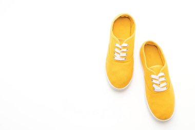 beyaz zemin üzerine sarı spor ayakkabı