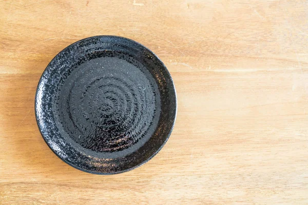 Plato negro vacío en la mesa — Foto de Stock
