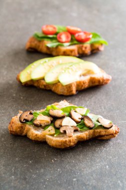 kruvasan sandviç avokado, domates ve mantar ile