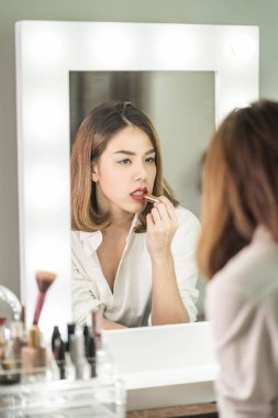 Genç güzel Asyalı ayna yakınındaki makyaj yapma kadın