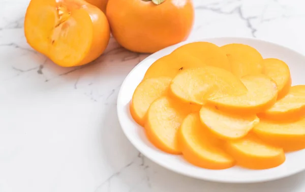 Sliced persimmon on plate — Stock Photo, Image