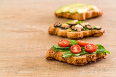 kruvasan sandviç avokado, domates ve mantar ile