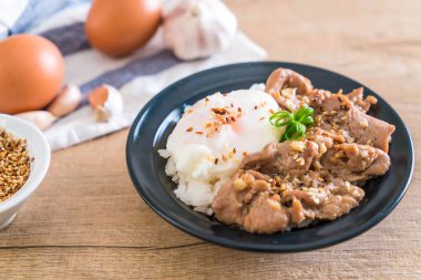 yumurta ile tepesinde pirinç Sarımsak soslu tavada kızartılmış domuz eti