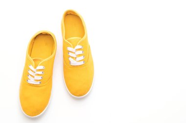 beyaz zemin üzerine sarı spor ayakkabı