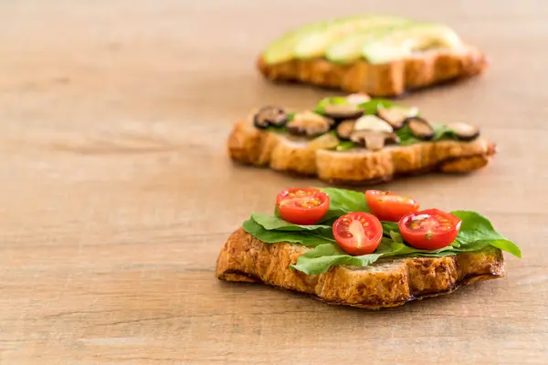 Sándwich de croissant con aguacate, tomates y champiñones — Foto de Stock