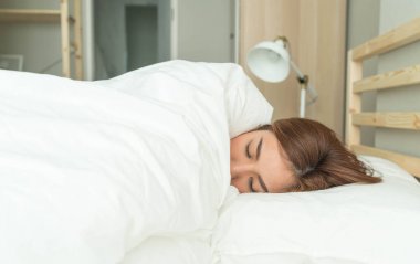 Yatakta uyuyan Asyalı kadın