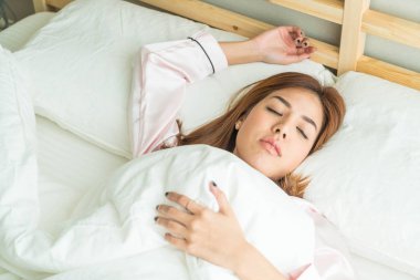 Yatakta uyuyan Asyalı kadın