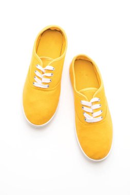 beyaz zemin üzerine sarı spor ayakkabı