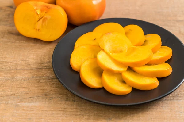 Sliced persimmon on plate — Stock Photo, Image