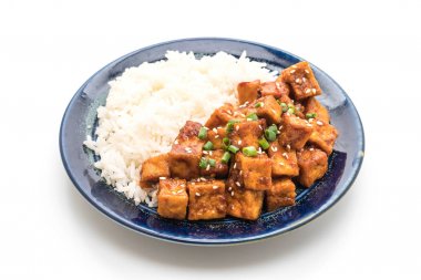 Baharatlı soslu Kızarmış tofu pirinç üzerine ilave edin.