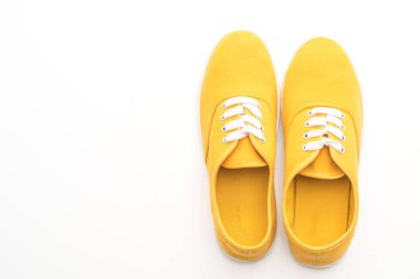 beyaz zemin üzerine sarı spor ayakkabı