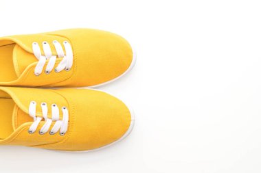 beyaz zemin üzerine sarı spor ayakkabı