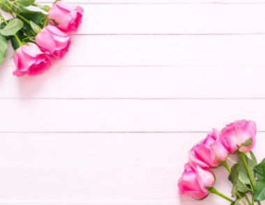 Ahşap arka plan üzerinde cam vazo içinde pembe Gül