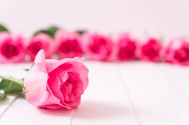 Ahşap arka plan üzerinde cam vazo içinde pembe Gül