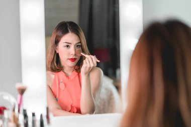Genç güzel Asyalı ayna yakınındaki makyaj yapma kadın