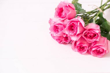 Ahşap arka plan üzerinde cam vazo içinde pembe Gül