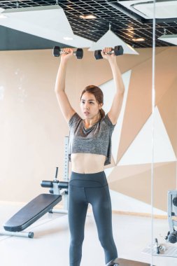 Asyalı kadın egzersiz jimnastik salonu dumbbells ile