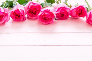 Ahşap arka plan üzerinde cam vazo içinde pembe Gül