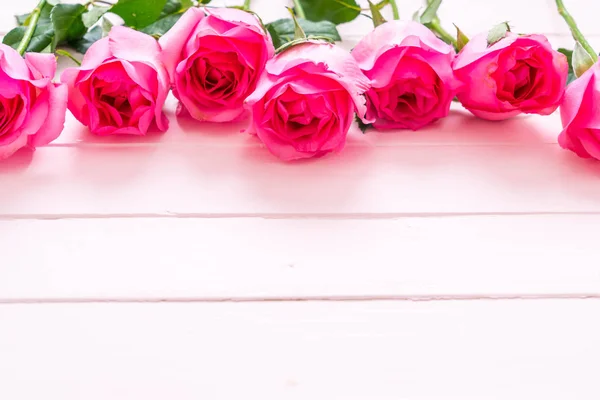 Rose rose dans un vase sur fond bois — Photo