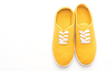 beyaz zemin üzerine sarı spor ayakkabı