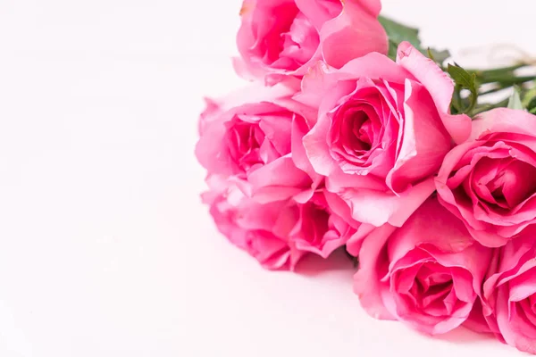 Roze roos in een vaas op hout achtergrond — Stockfoto