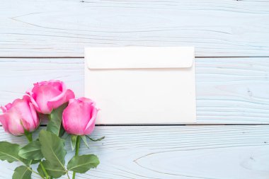 Ahşap arka plan üzerinde cam vazo içinde pembe Gül