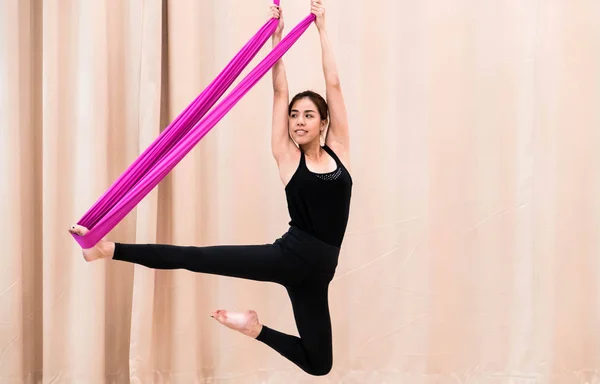 Asian woman training in fitness room with fly yoga elements — Stock Photo, Image