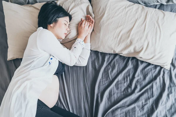 Wanita cantik Asia yang hamil tidur di tempat tidur — Stok Foto