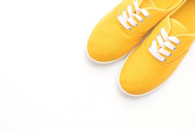 beyaz zemin üzerine sarı spor ayakkabı