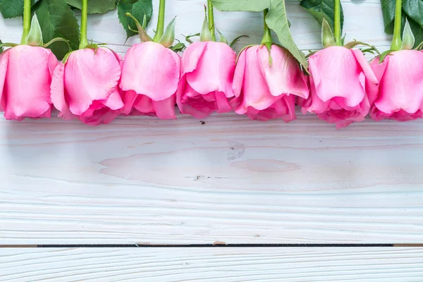 Rose rose dans un vase sur fond bois — Photo