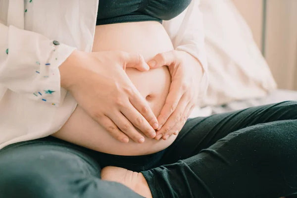 Joven hermosa asiática embarazada sosteniendo sus manos en un escuchar — Foto de Stock