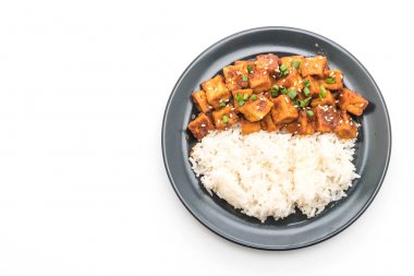 Baharatlı soslu Kızarmış tofu pirinç üzerine ilave edin.