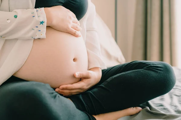 Belly terhes nő kezében — Stock Fotó
