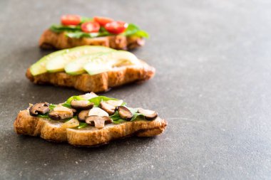 kruvasan sandviç avokado, domates ve mantar ile