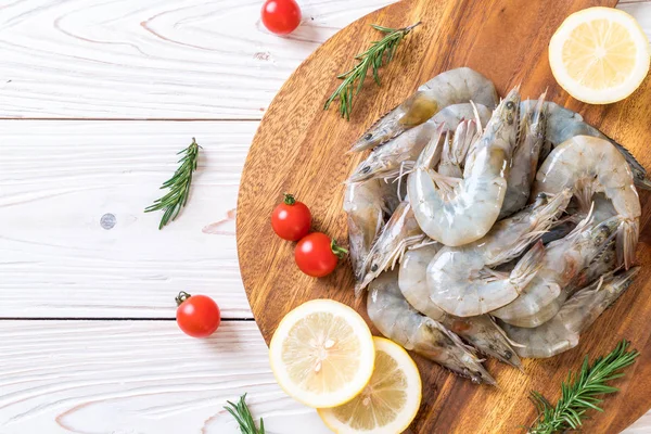 Fresh shrimps or prawns raw on wooden board — Stock Photo, Image