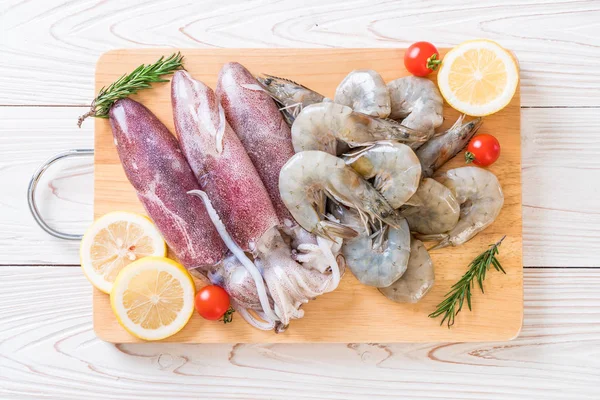 taze deniz ürünleri ham (karides, mürekkep) ahşap tahta üzerinde 