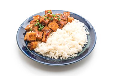 Baharatlı soslu Kızarmış tofu pirinç üzerine ilave edin.