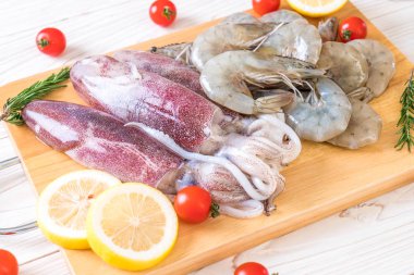 taze deniz ürünleri ham (karides, mürekkep) ahşap tahta üzerinde 