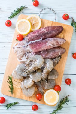 taze deniz ürünleri ham (karides, mürekkep) ahşap tahta üzerinde 