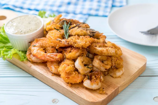 Fried seafood (squids, shrimps, mussels) with sauce — Stock Photo, Image