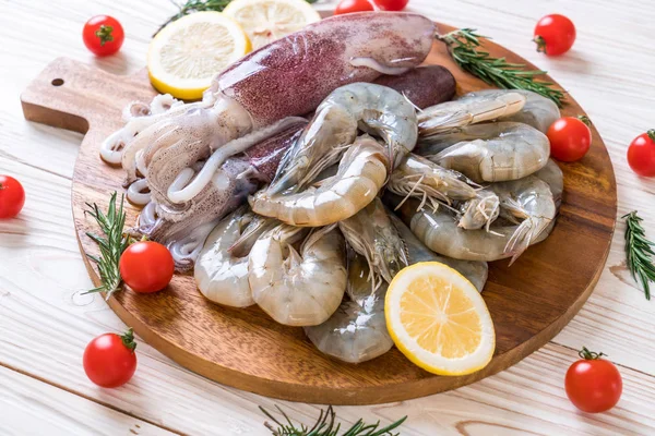 taze deniz ürünleri ham (karides, mürekkep) ahşap tahta üzerinde 