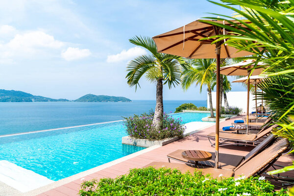 Umbrella and chair around swimming pool in hotel and resort 