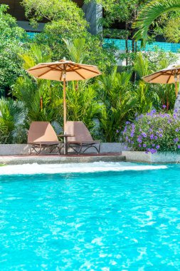 Güzel şemsiye ve sandalye etrafında yüzme havuzunda otel ve r