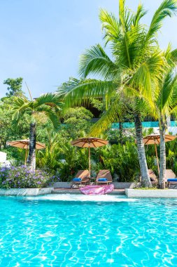 Güzel şemsiye ve sandalye etrafında yüzme havuzunda otel ve r